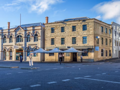 Wide exterior view of the historic sandstone warehouses on the corner of Salamanca Place